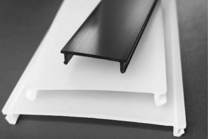 Extruded plastic profile for LED lighting applications, providing structural support and light guidance