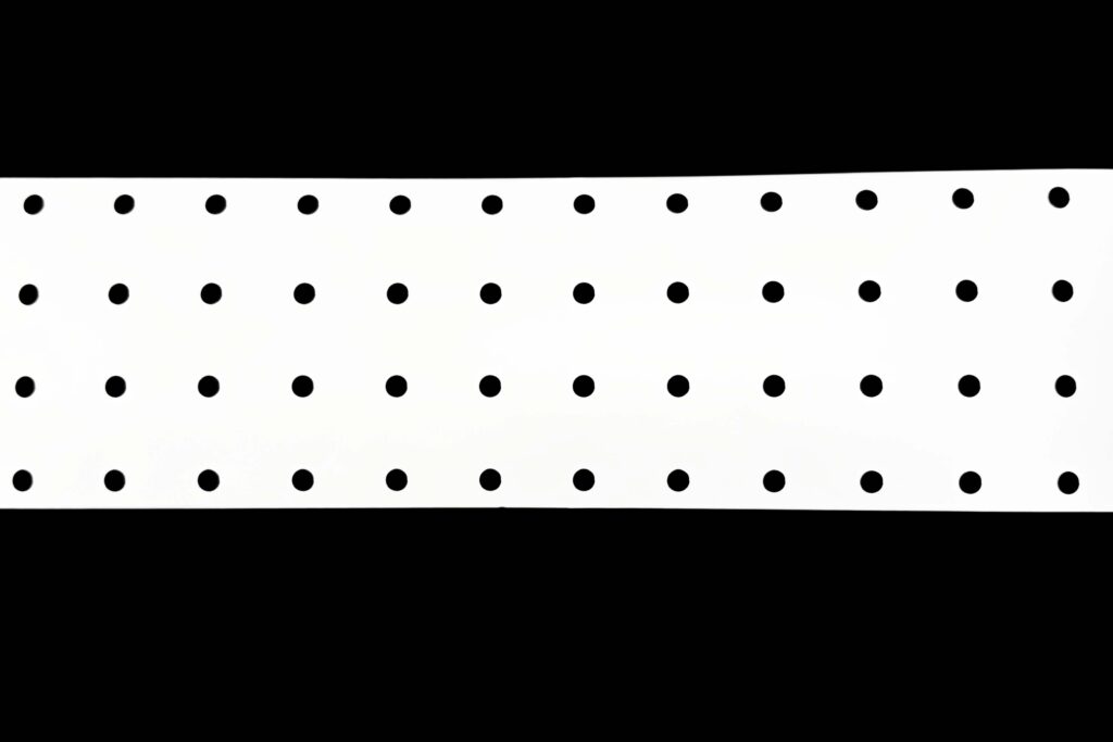 White PET reflector film roll with circular perforations for LED lighting assemblies
