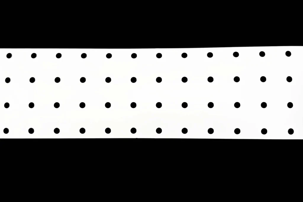 White PET reflector film roll with circular perforations for LED lighting assemblies